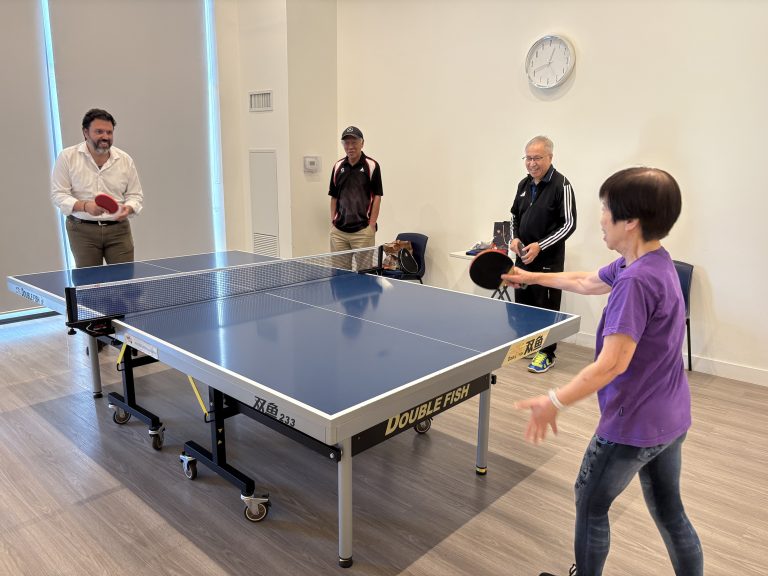Nick playing ping pong with seniors